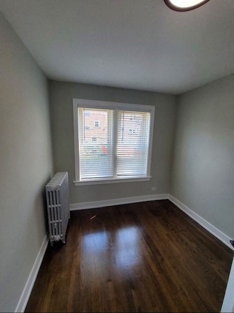 an empty room with a window and wooden floors