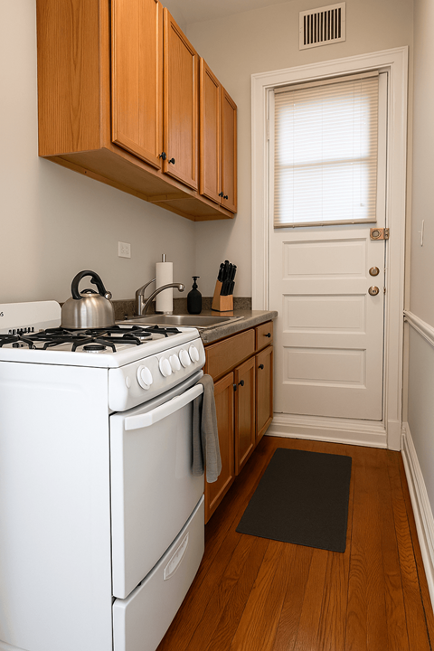 A white stove and oven in a kitchen with wooden cabinets.