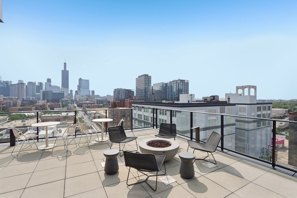 A patio with a table and chairs overlooking a city skyline.