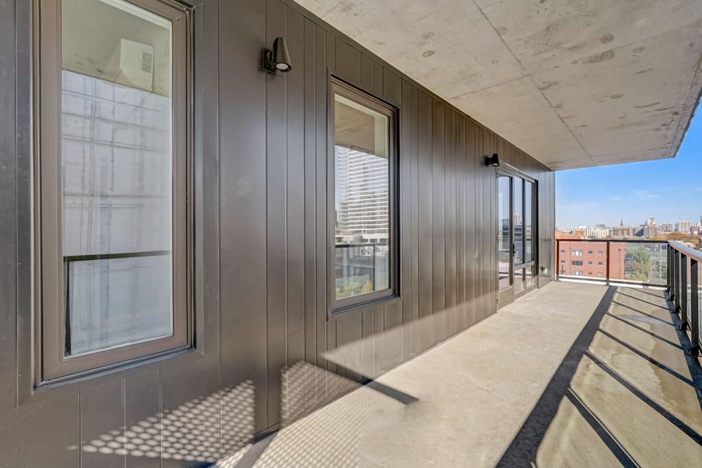 A long corridor with windows on the side and a tiled floor.