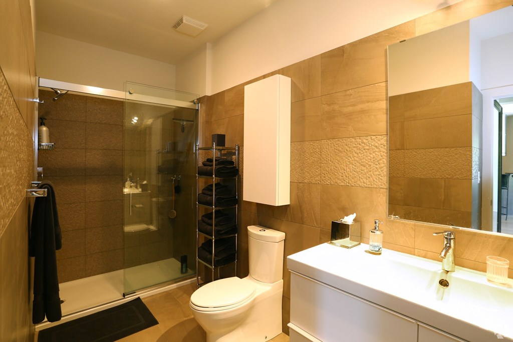 A bathroom with a toilet, sink, and shower.