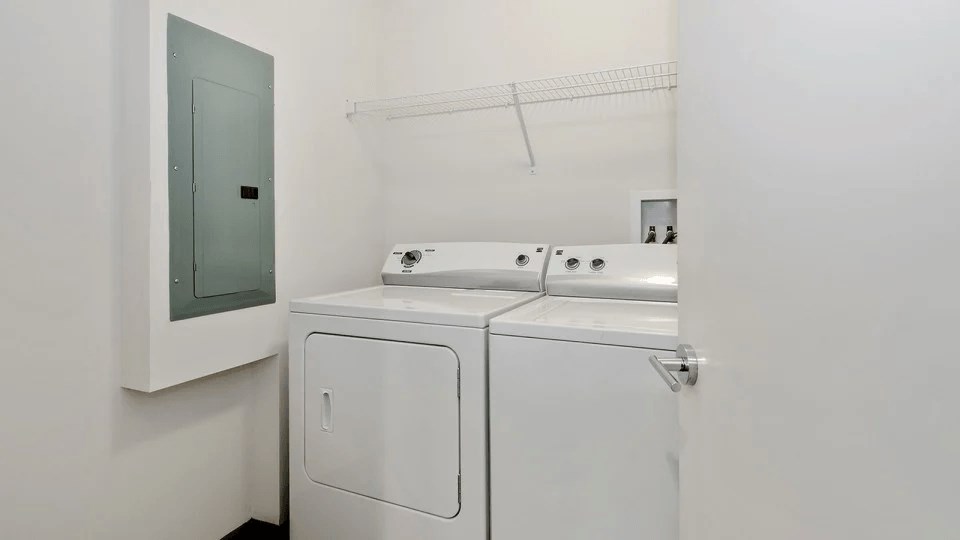 A white bathroom with a toilet, sink, and cabinet.