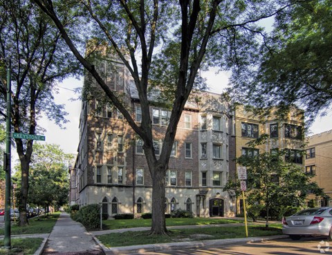 an apartment building on a city street with trees