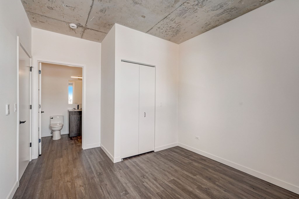 A room with a toilet and a white door.