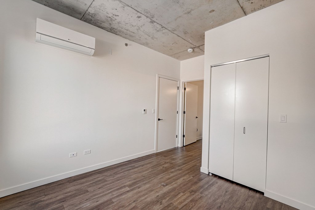 A room with a white wall and a wooden floor.