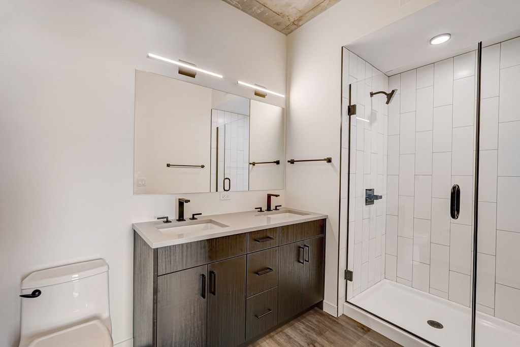 A bathroom with a sink, mirror, and shower.