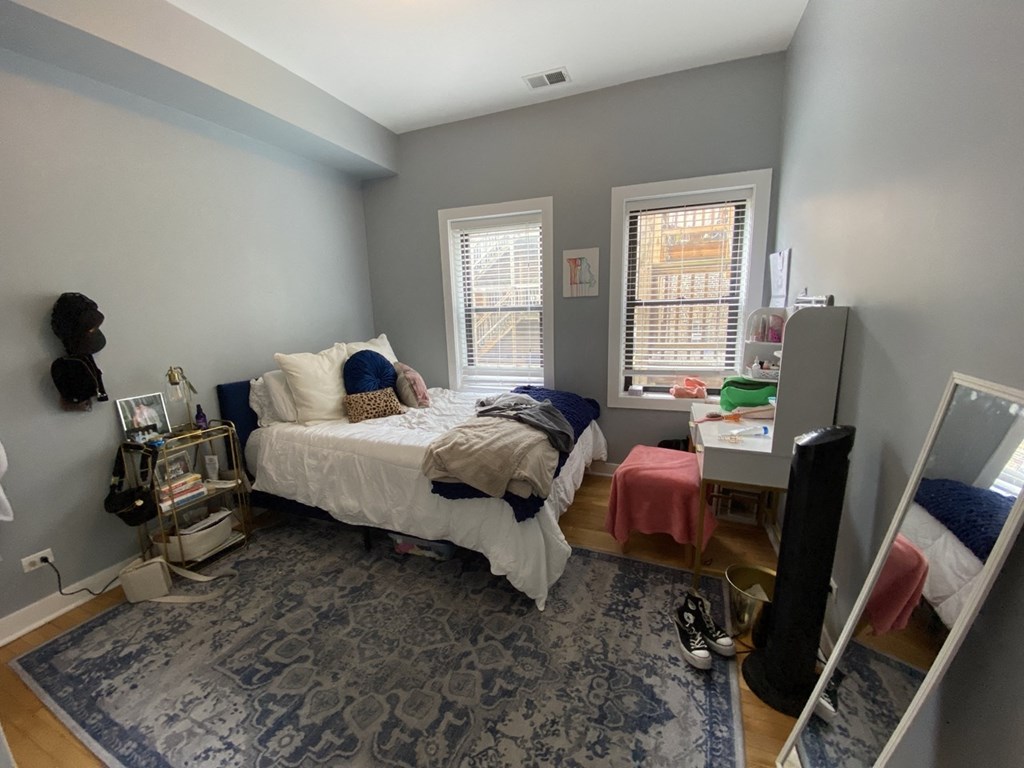 a bedroom with a bed and a desk and a tv