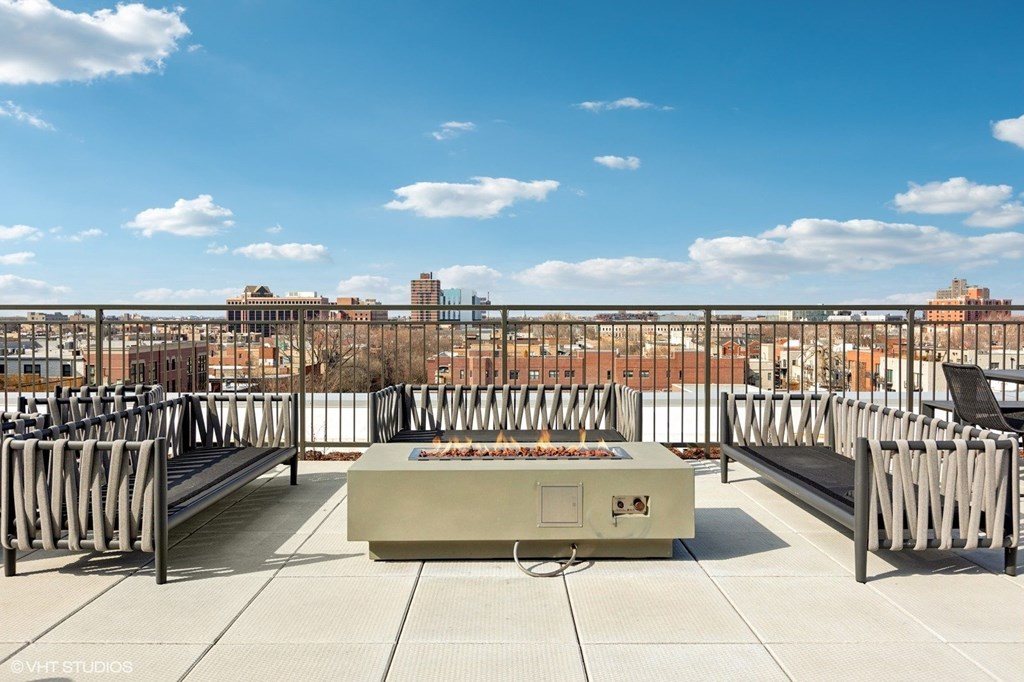 A large metal box sits in the middle of a rooftop with a cloudy sky in the background.