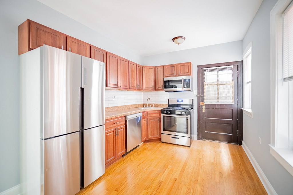 a kitchen with wooden cabinets and stainless steel appliances