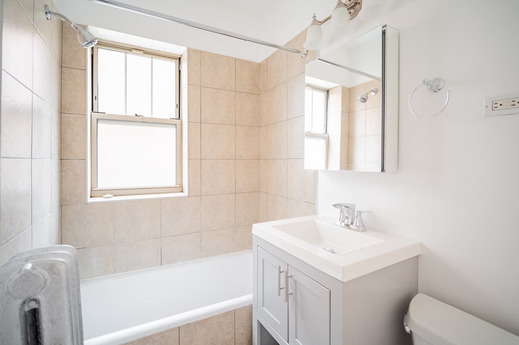 a bathroom with a sink and a bath tub and a mirror