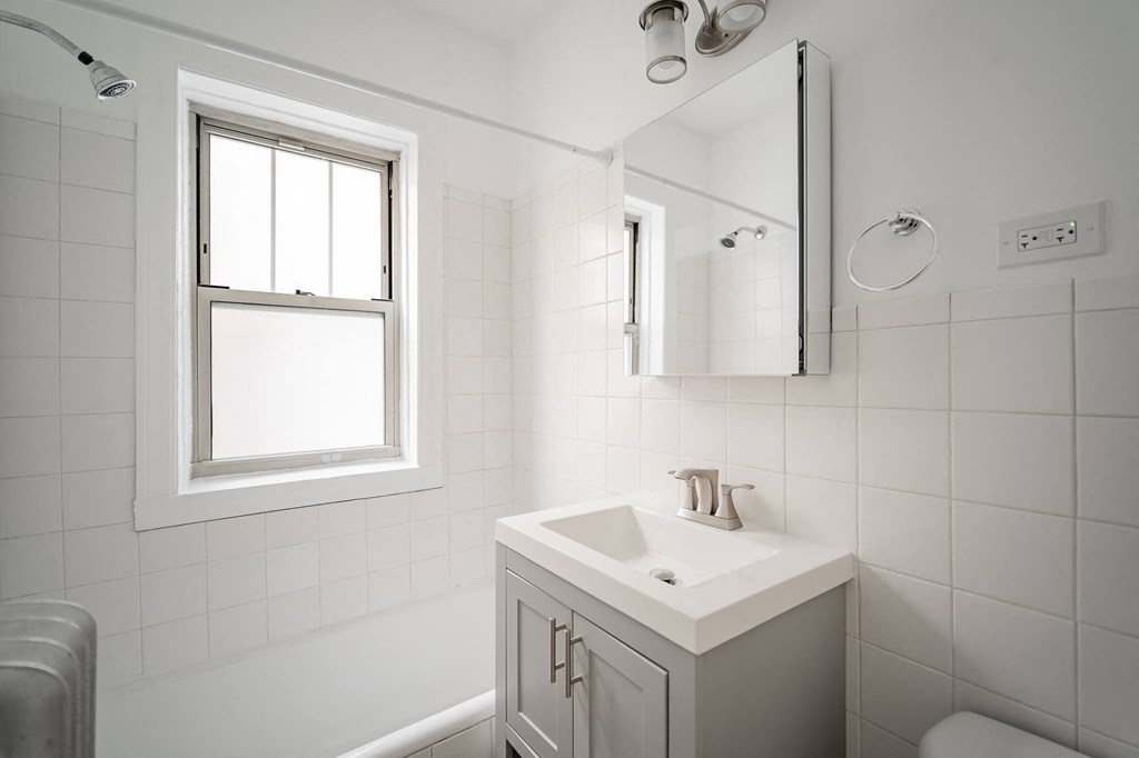 a white bathroom with a sink and a mirror