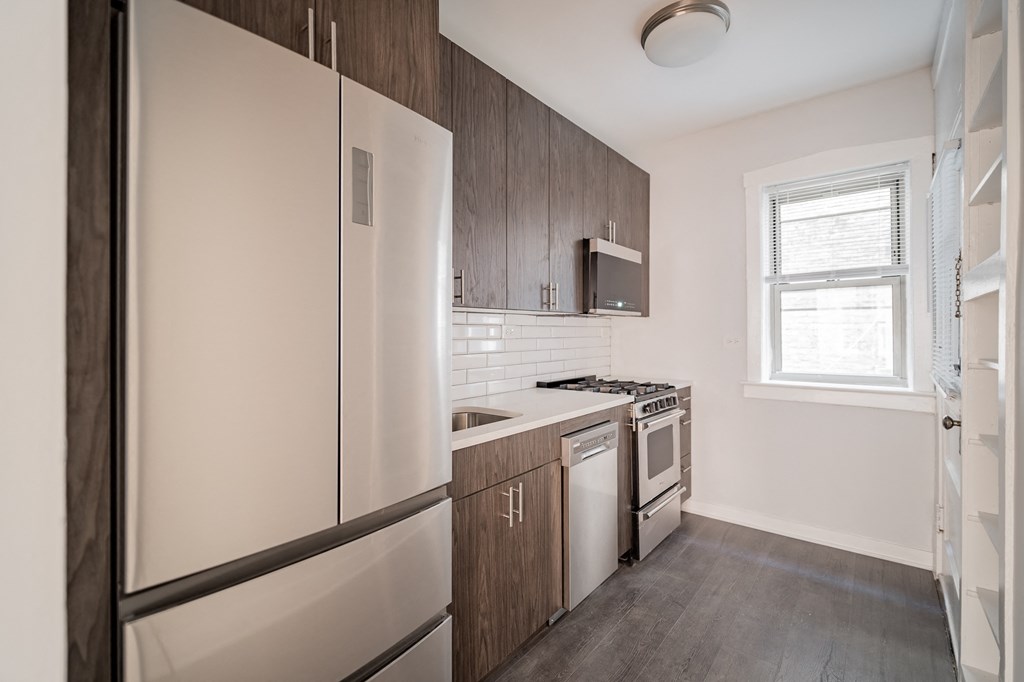 a kitchen with white appliances and wooden cabinets and a refrigerator