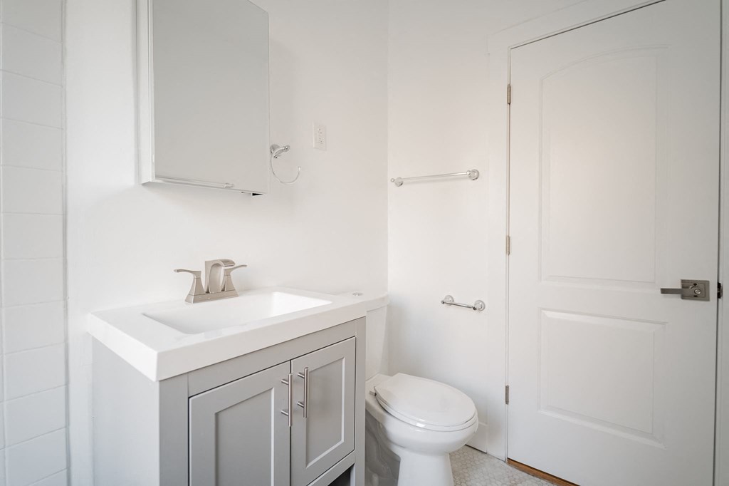 a bathroom with a sink toilet and a white door