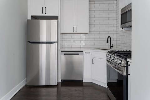 A modern kitchen with a stainless steel refrigerator and oven.