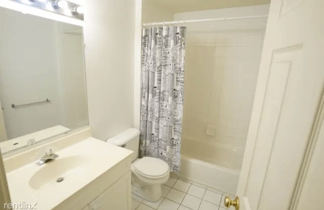 a bathroom with a toilet and a sink and a shower