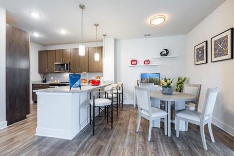 A modern kitchen with a dining table set for four.