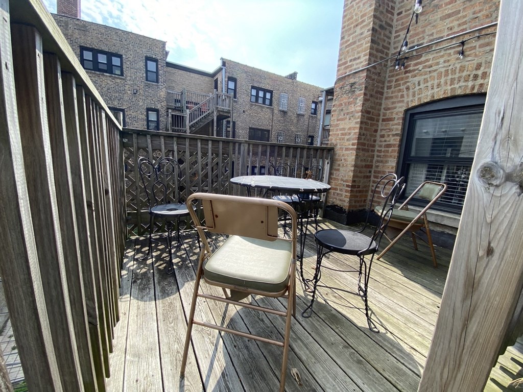 a balcony with a table and chairs and a brick building