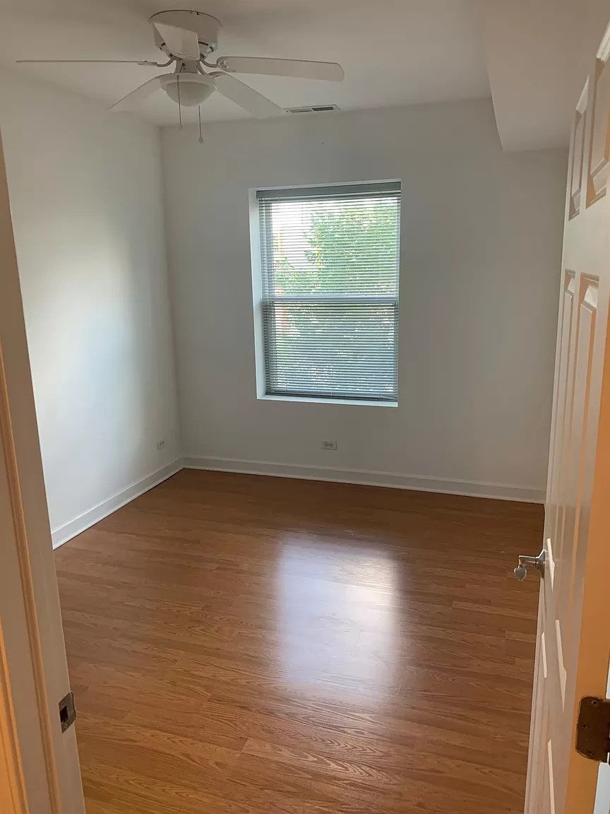 an empty room with a window and wooden floors