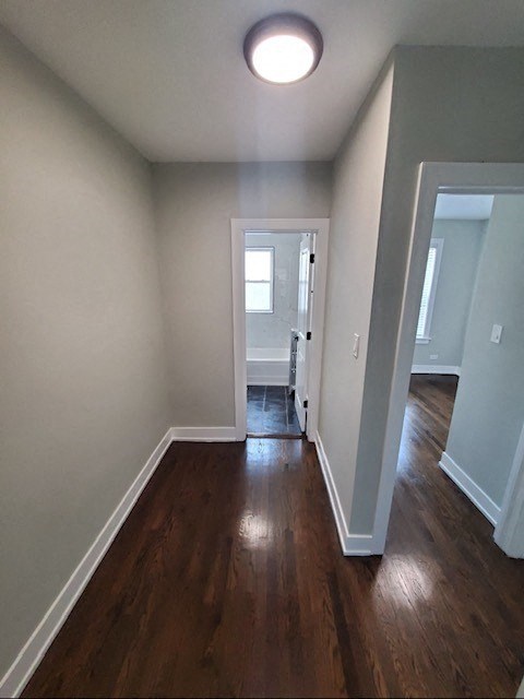 a empty room with a wooden floor and a door to a bathroom