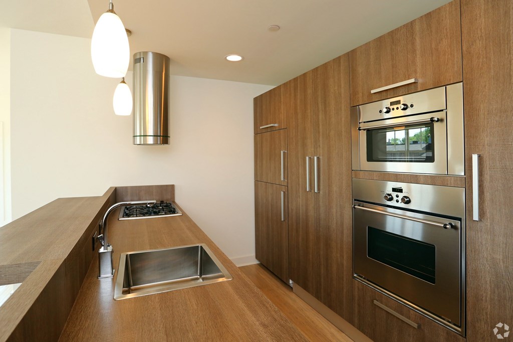 A modern kitchen with wooden cabinets and stainless steel appliances.