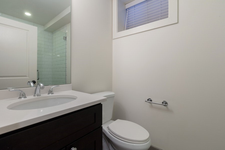 A white toilet sits next to a sink in a bathroom.