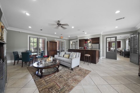 A spacious living room with a fireplace and a rug on the floor.