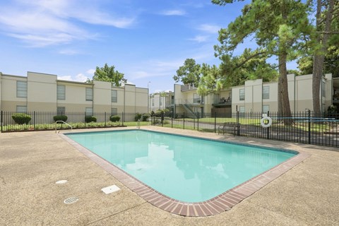 A small pool in a courtyard surrounded by buildings.