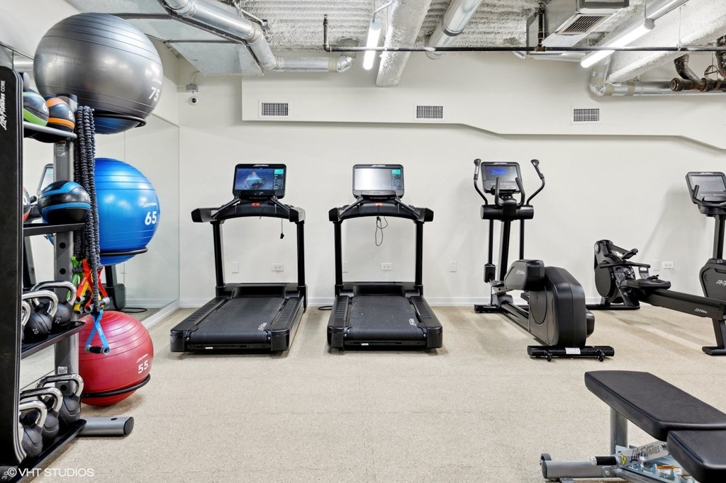 A gym with treadmills, exercise bikes, and other equipment.