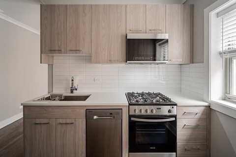 A modern kitchen with a stove, sink, and cabinets.