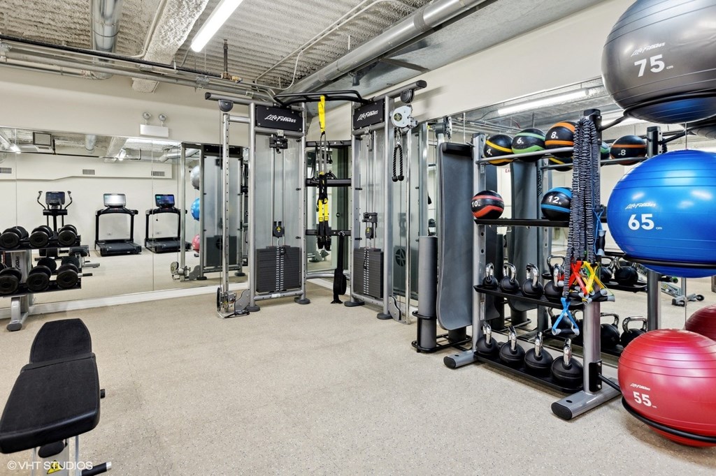 A gym with a variety of equipment including weights and weight machines.