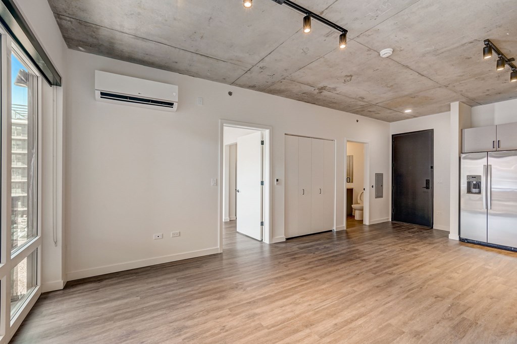 A spacious room with a wooden floor and a ceiling with exposed beams.