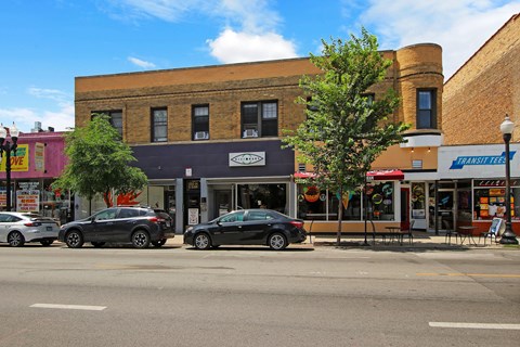 a city street with cars parked in front of a brick building