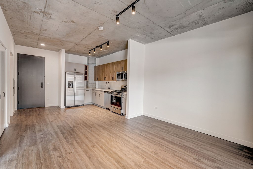 A kitchen with wooden floors and a white wall.