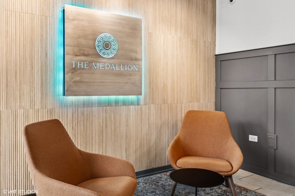 Two tan chairs are placed in front of a sign that says "The Medallion".