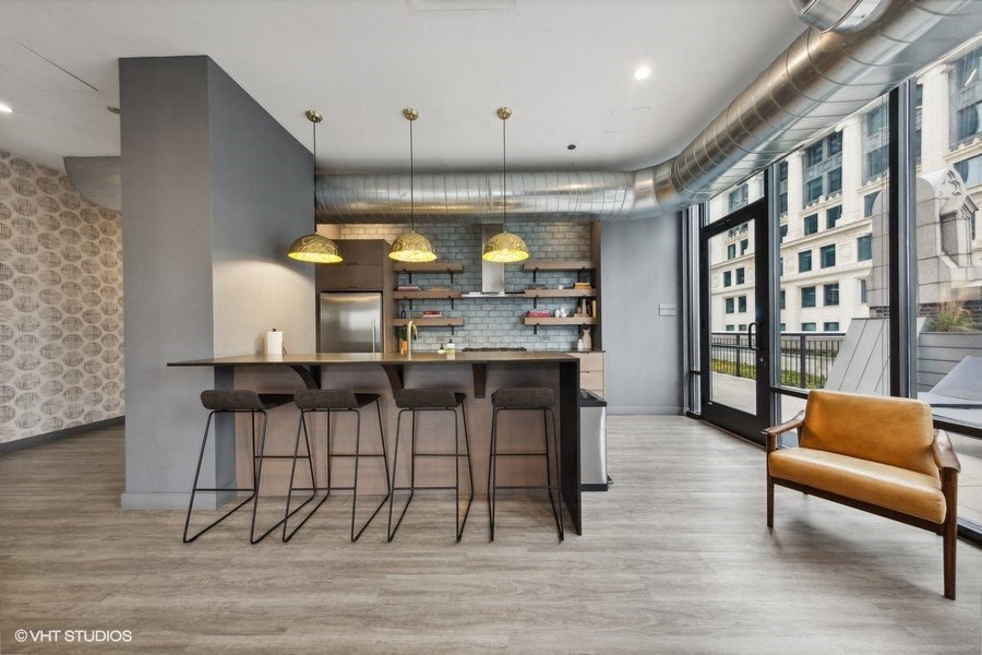 a kitchen with a bar and stools in a loft apartment
