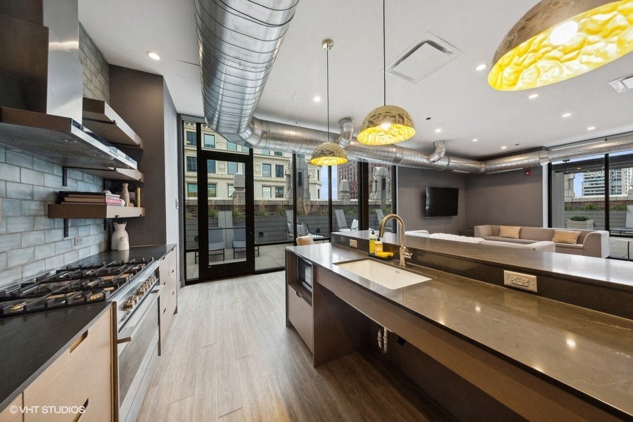 the kitchen has stainless steel appliances and a large island