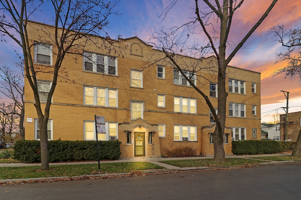 an apartment building with a sunset in the background