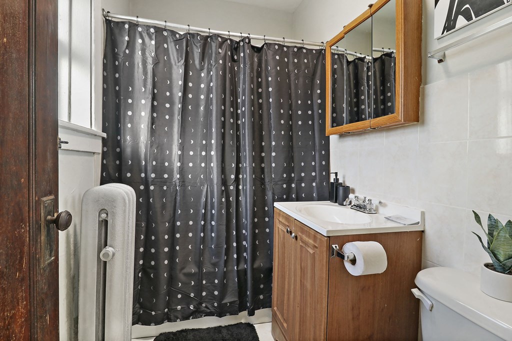 a bathroom with a shower and sink and a shower curtain