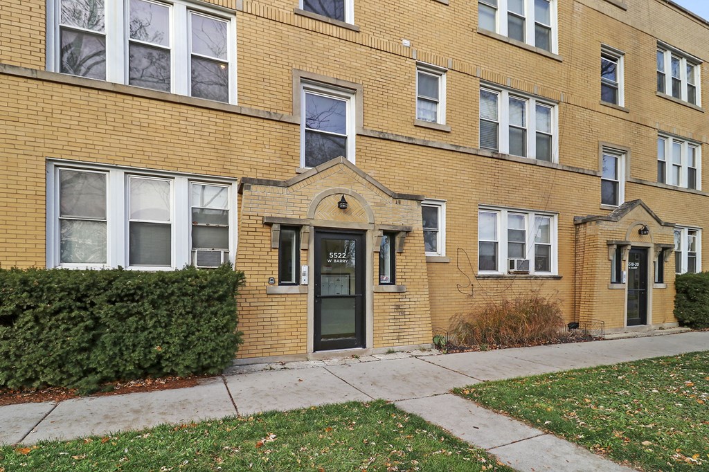 a brick building with a sidewalk in front of it
