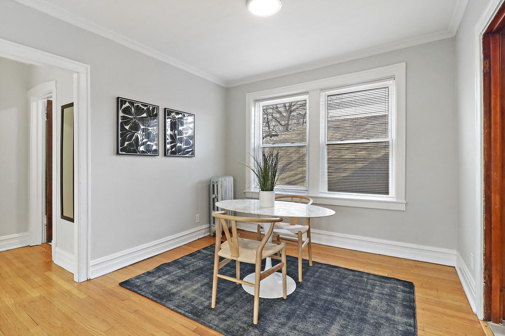 a dining room with a table and chairs and a window