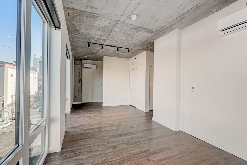 A room with a window and a white wall.