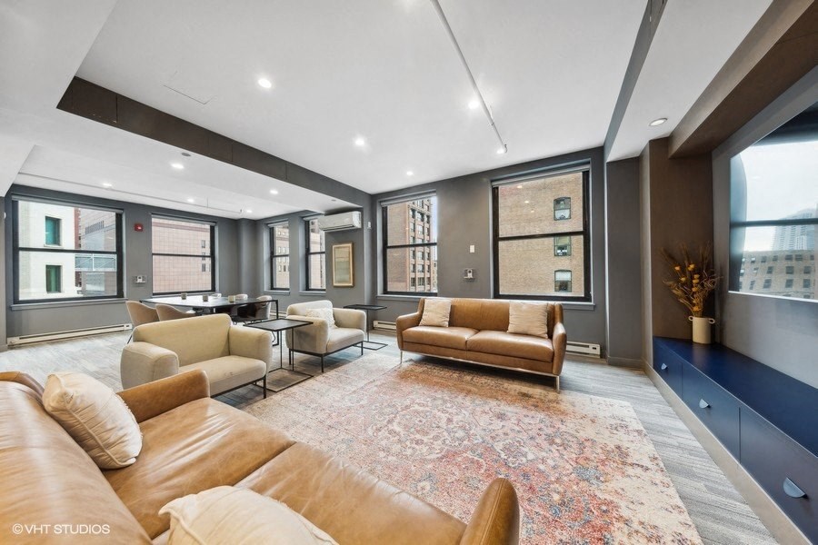 a living room with couches and chairs and a rug
