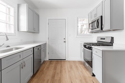 A kitchen with white cabinets and appliances.
