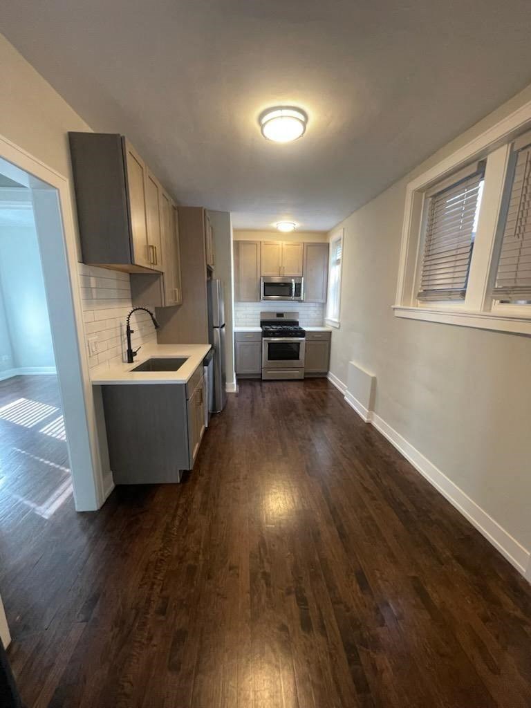 an empty kitchen with a wooden floor and