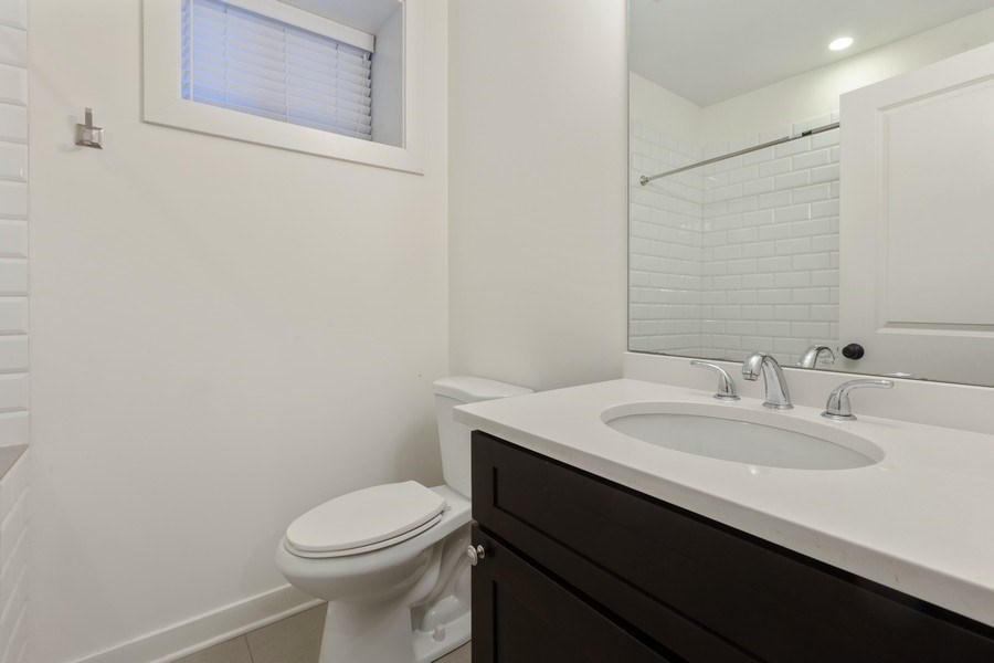 A white toilet sits next to a white sink in a bathroom.