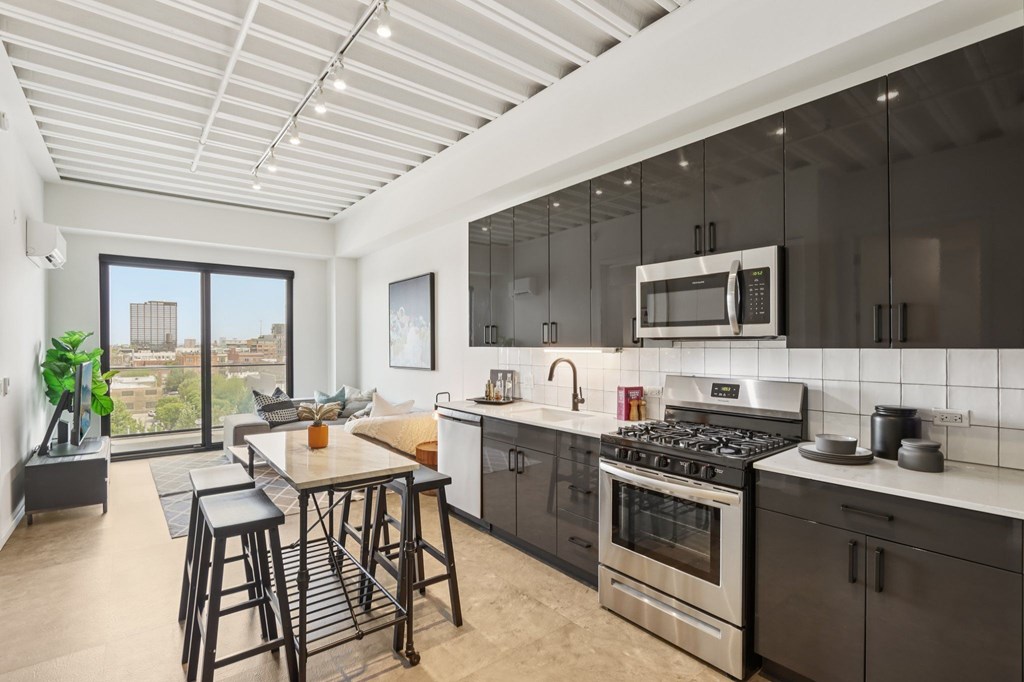 A modern kitchen with a bar stool and a view of the city.