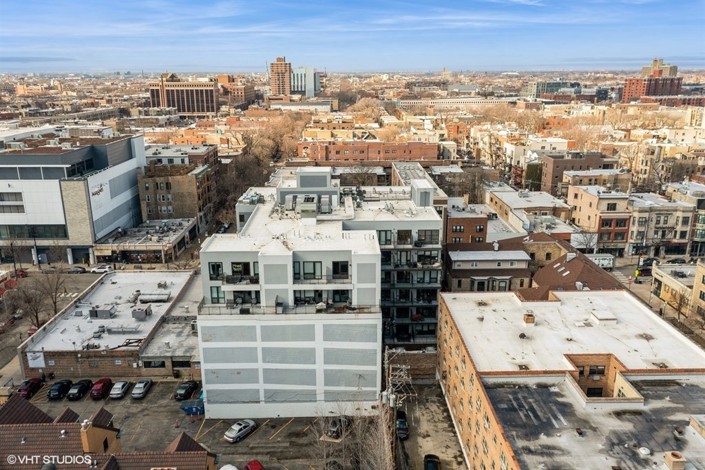 A cityscape with a large white building in the foreground.