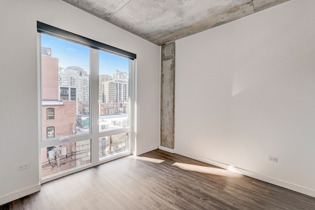 A room with a view of the city through a large window.