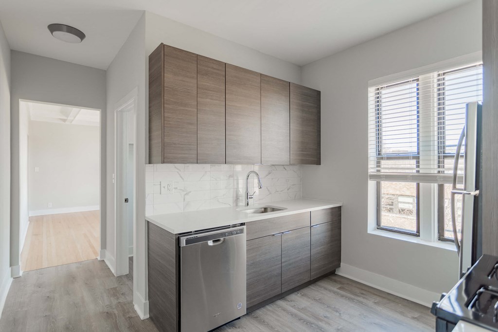 a kitchen with wooden cabinets and a stainless steel dishwasher