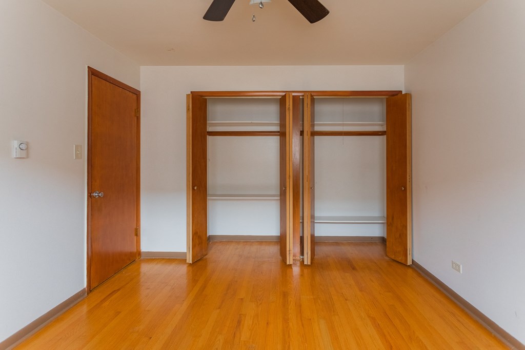 an empty room with wooden floors and two closet doors